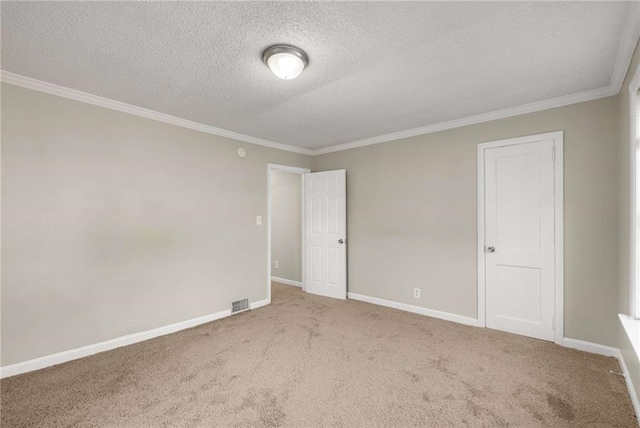 carpeted empty room featuring a textured ceiling and crown molding