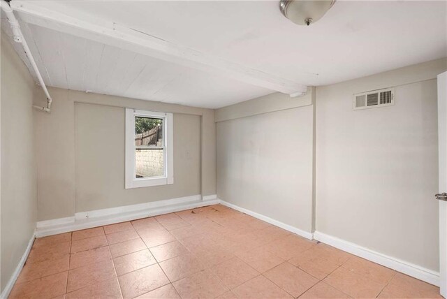 spare room with beam ceiling