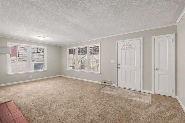 entrance foyer featuring a textured ceiling, carpet floors, and ornamental molding