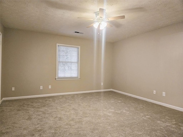 empty room with ceiling fan, a textured ceiling, and carpet flooring