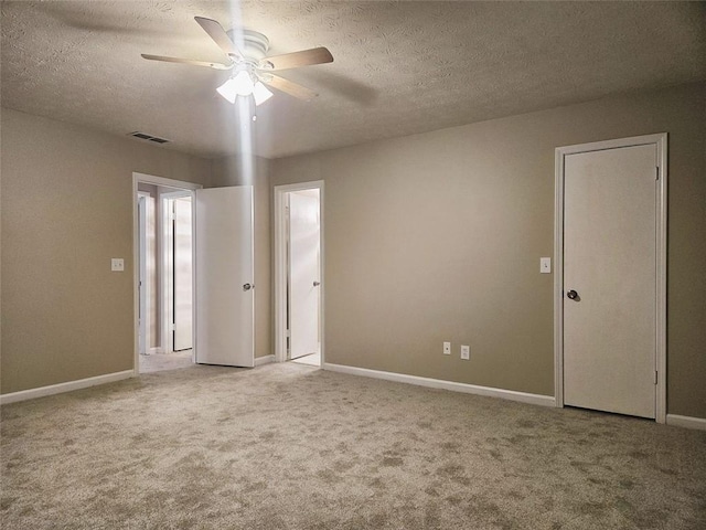 unfurnished room featuring ceiling fan, a textured ceiling, and light carpet