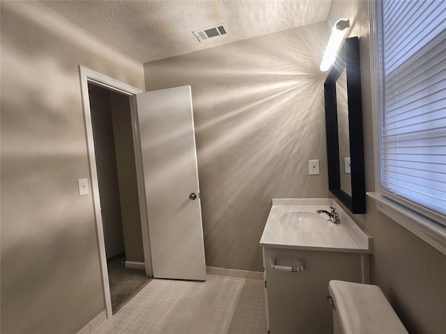 bathroom featuring a textured ceiling and vanity