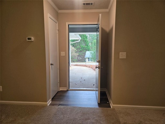 doorway with dark carpet and ornamental molding