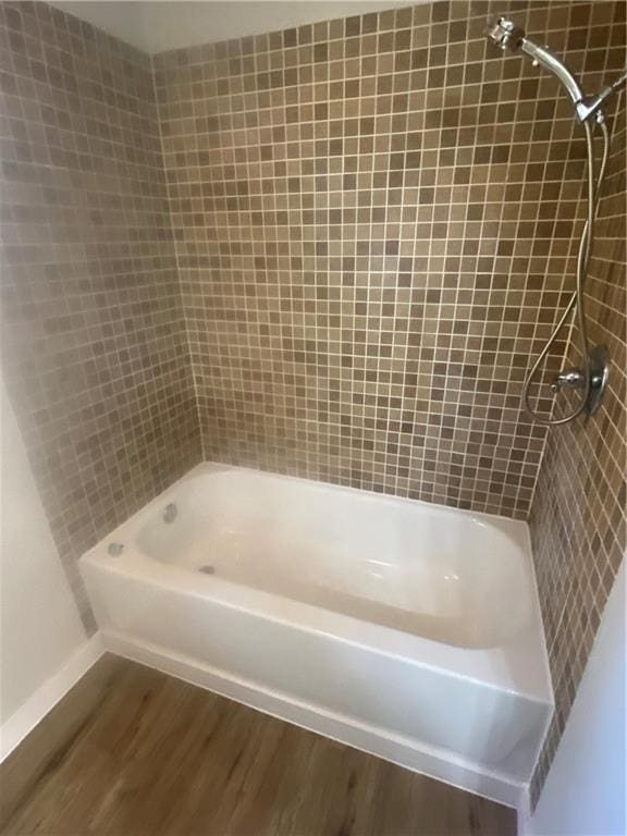 bathroom featuring hardwood / wood-style floors and tiled shower / bath combo