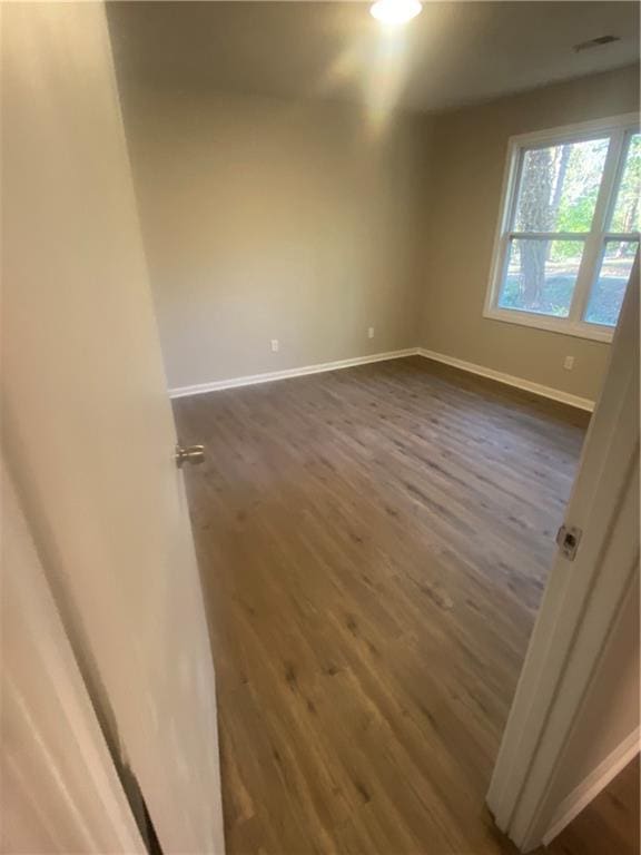 empty room with dark hardwood / wood-style floors