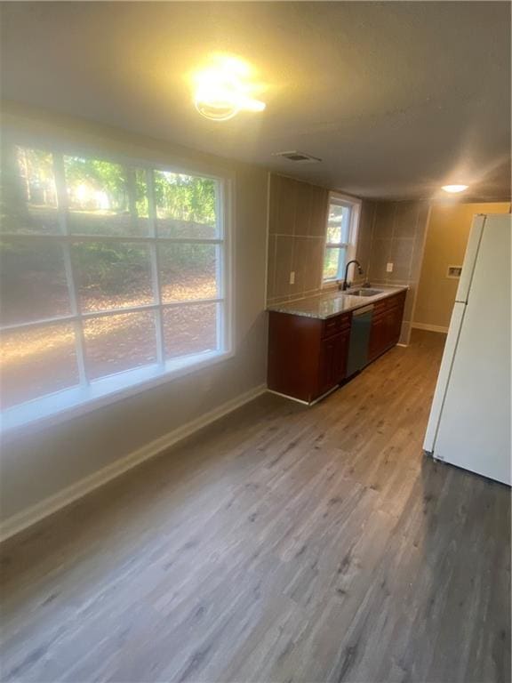 kitchen featuring hardwood / wood-style floors, dishwasher, white refrigerator, and sink