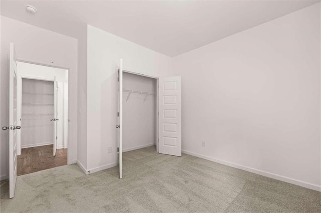 unfurnished bedroom featuring light colored carpet and a closet