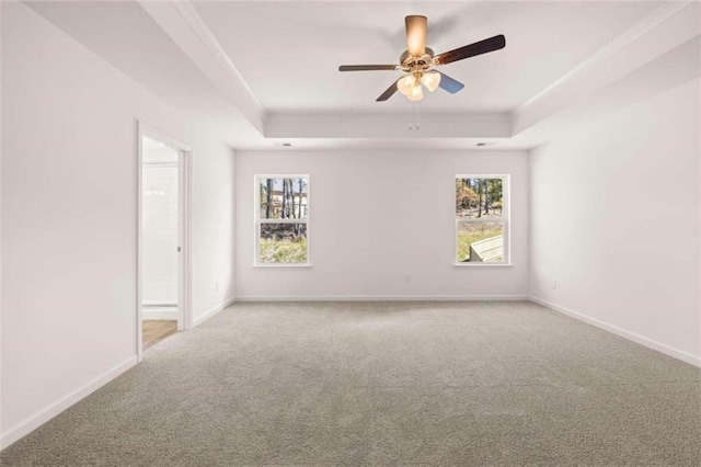 unfurnished room featuring ceiling fan, carpet flooring, and a raised ceiling