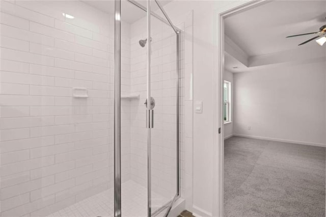 bathroom featuring a shower with shower door and ceiling fan