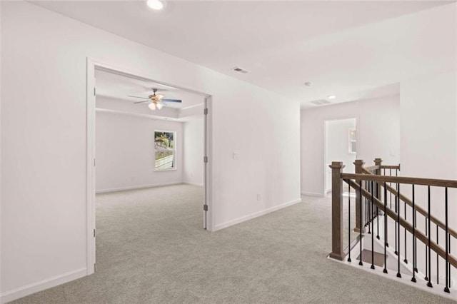 hallway featuring light colored carpet