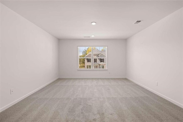 spare room featuring light colored carpet