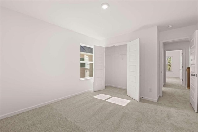 unfurnished bedroom featuring a closet and light colored carpet