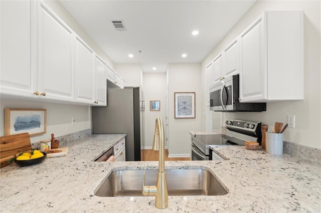 1024 Whitshire Way, Alpharetta, GA 30004 - kitchen featuring appliances with stainless steel finishes, light stone countertops, white cabinets, and recessed lighting