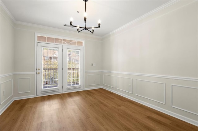1024 Whitshire Way, Alpharetta, GA 30004 - unfurnished dining area featuring a chandelier, a decorative wall, wood finished floors, ornamental molding, and wainscoting