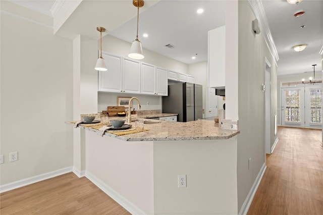 1024 Whitshire Way, Alpharetta, GA 30004 - kitchen featuring freestanding refrigerator, crown molding, light wood-style floors, light stone counters, and white cabinets