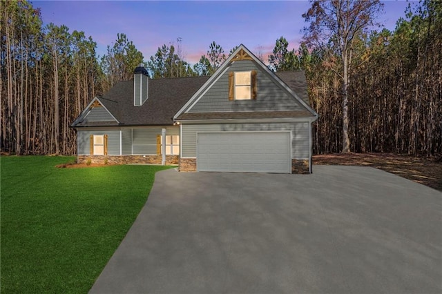 view of front of house featuring a garage and a yard