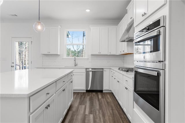 kitchen with sink, hanging light fixtures, white cabinets, and appliances with stainless steel finishes