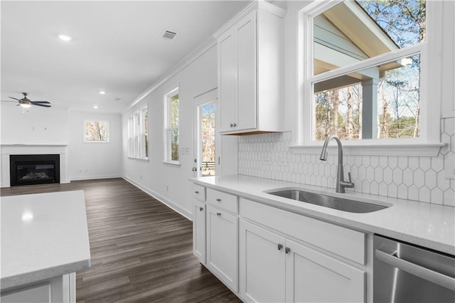 1495 Auburn Glen Rd, Dacula, GA 30019 - kitchen with stainless steel dishwasher, a sink, a ceiling fan, backsplash, and light countertops