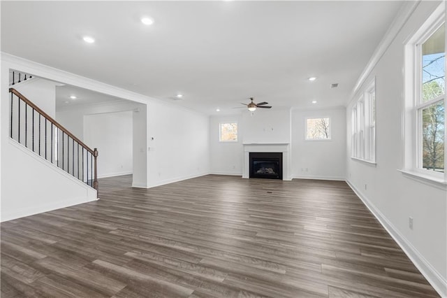 unfurnished living room with crown molding, ceiling fan, and dark hardwood / wood-style floors