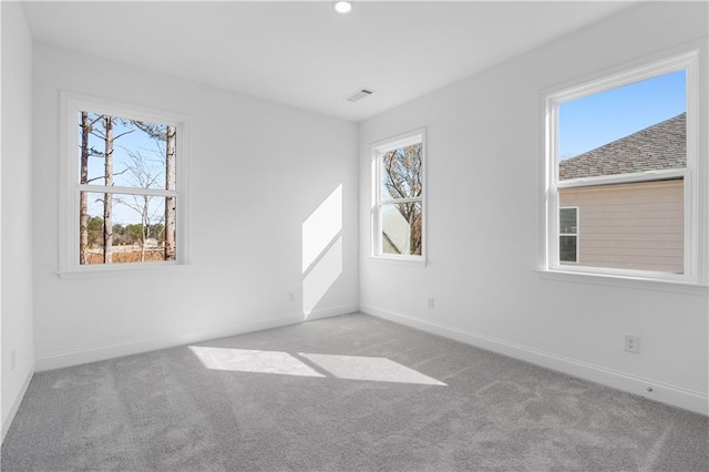 unfurnished room with a wealth of natural light and light colored carpet