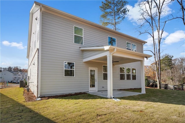 back of property with central AC unit, a yard, a patio area, and ceiling fan