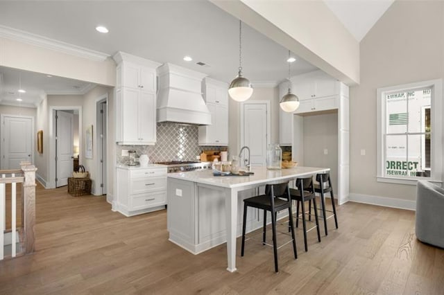 kitchen featuring custom range hood, white cabinetry, decorative backsplash, and crown molding