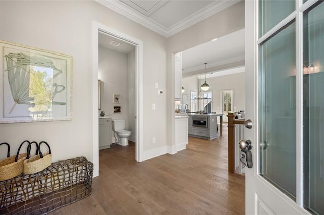 interior space featuring baseboards, ornamental molding, and wood finished floors