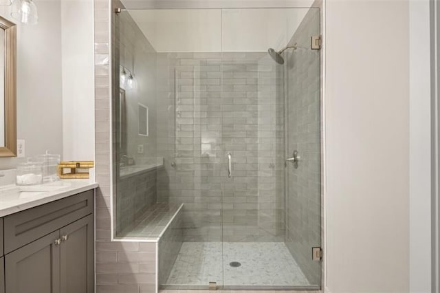 bathroom with a shower stall and vanity