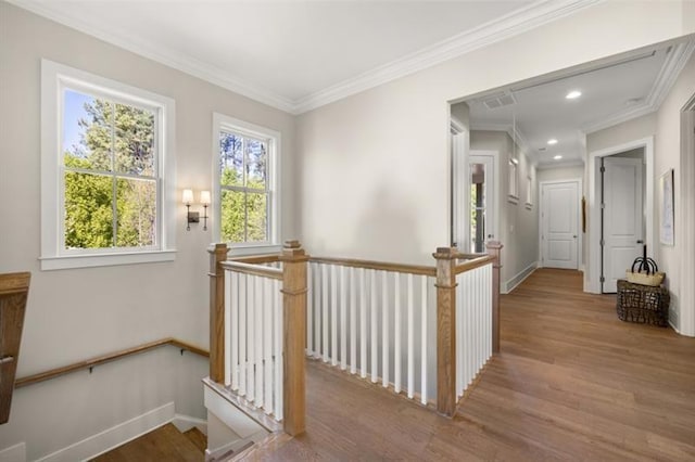 corridor featuring ornamental molding, baseboards, an upstairs landing, and wood finished floors