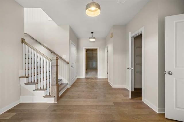 entryway with stairs, baseboards, and wood finished floors