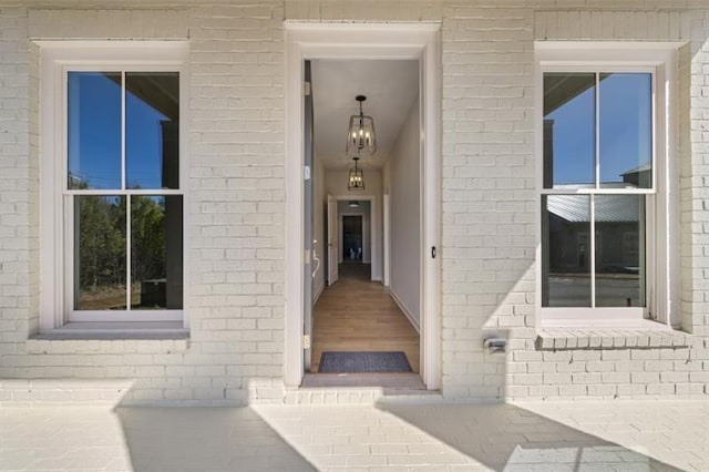 view of exterior entry featuring brick siding