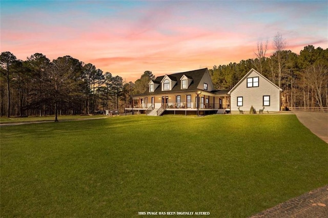 back house at dusk featuring a yard and a porch