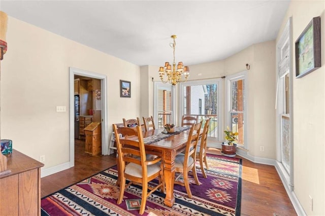 dining space featuring dark hardwood / wood-style floors and a chandelier