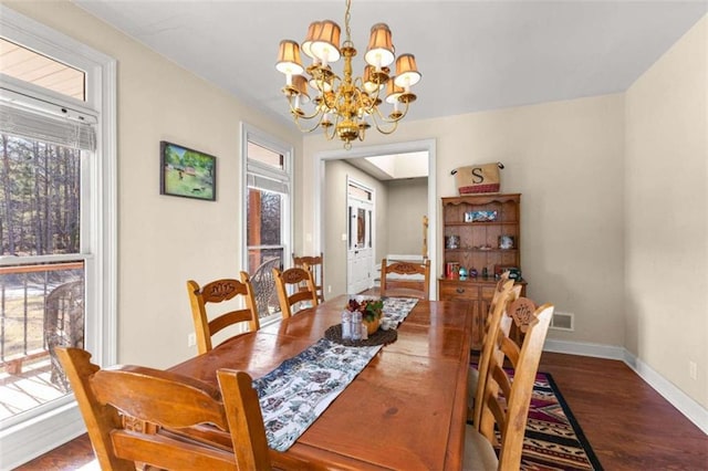 dining room with dark hardwood / wood-style flooring and a chandelier