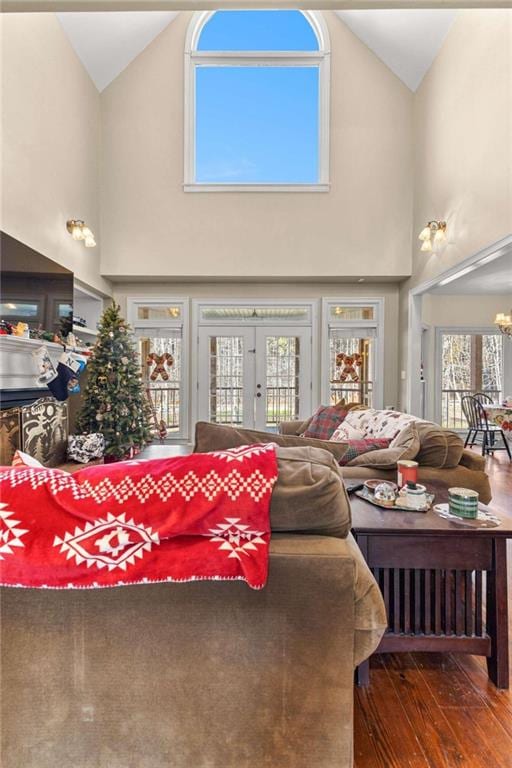 living room featuring high vaulted ceiling, french doors, dark wood-type flooring, and a chandelier