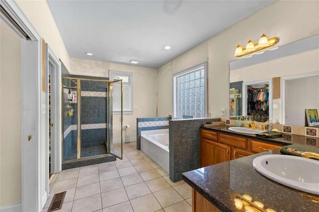 bathroom with tile patterned floors, vanity, and separate shower and tub