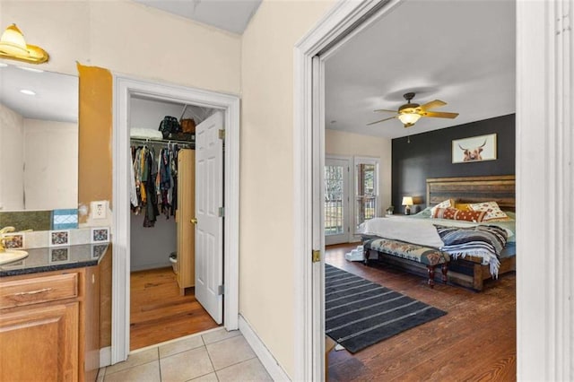 tiled bedroom with ceiling fan and a closet