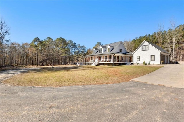 cape cod home with covered porch, a front yard, and a garage