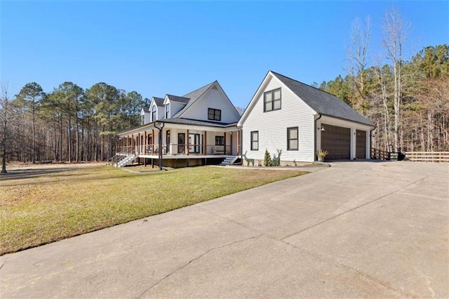 view of front of home with covered porch, a front lawn, and a garage