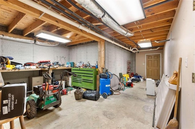 basement featuring brick wall and a workshop area