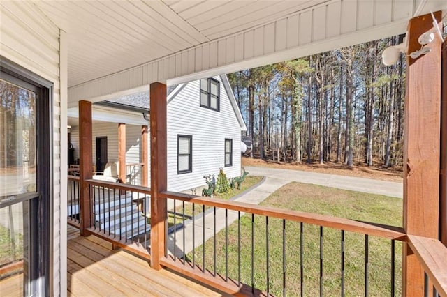 wooden deck with covered porch and a yard