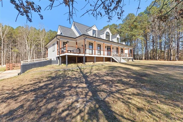 new england style home featuring covered porch and a front yard