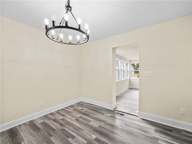 239 Brown Dr, Clermont, GA 30527 - unfurnished dining area with a chandelier, visible vents, baseboards, and wood finished floors