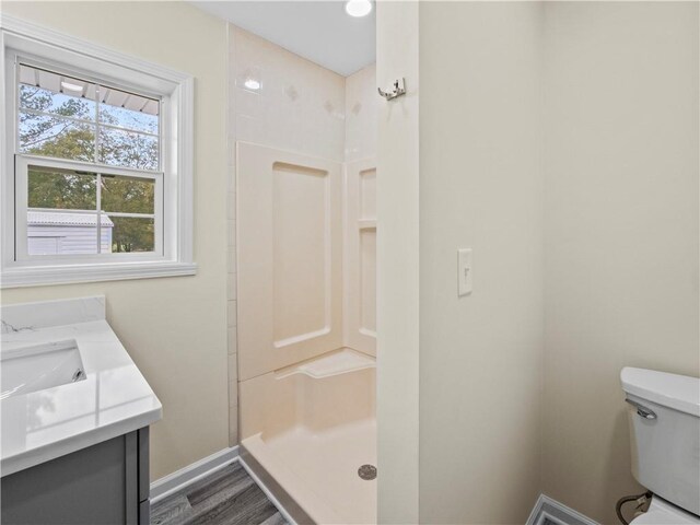 239 Brown Dr, Clermont, GA 30527 - full bath featuring vanity, wood finished floors, baseboards, a stall shower, and toilet