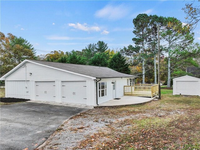 239 Brown Dr, Clermont, GA 30527 - exterior space featuring a shingled roof, a shed, a wooden deck, a garage, and an outdoor structure