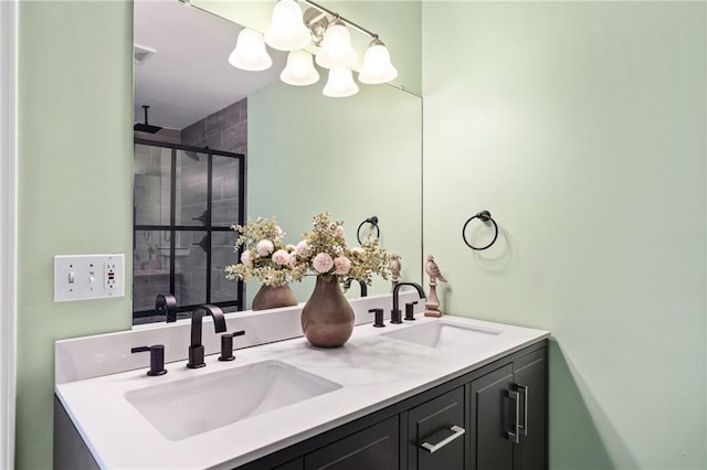 bathroom featuring a shower with door, an inviting chandelier, and vanity