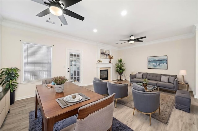 living room featuring light wood-type flooring, ceiling fan, and ornamental molding