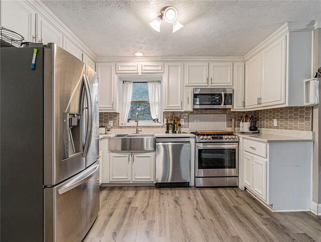 kitchen featuring a sink, white cabinetry, appliances with stainless steel finishes, and light countertops