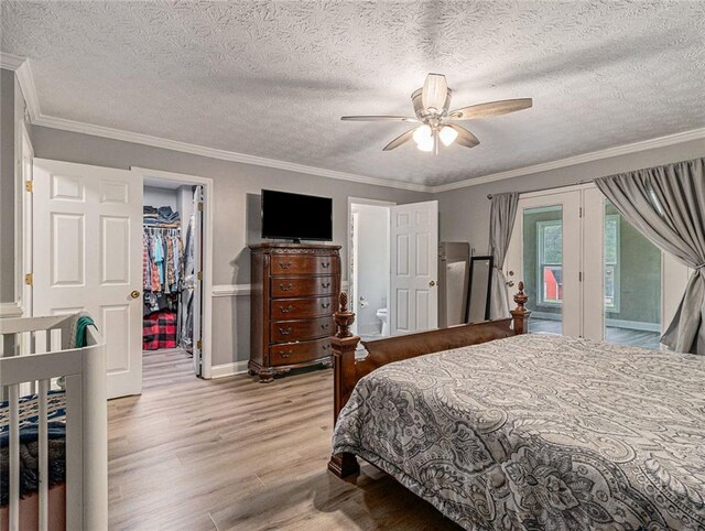 bedroom featuring crown molding, access to outside, wood finished floors, and a spacious closet