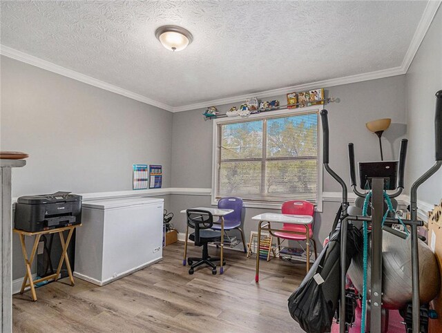 playroom featuring baseboards, a textured ceiling, ornamental molding, and wood finished floors